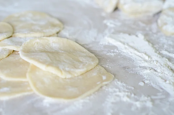 Hamur ile daireler haddelenmiş, un serpilir. Pierog yapımı — Stok fotoğraf