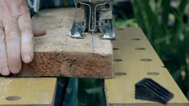 El hombre aserró una tabla de madera con un rompecabezas eléctrico . — Vídeo de stock