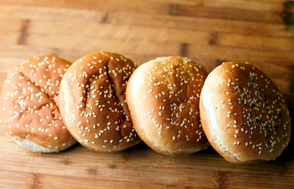 De hamburgerbroodjes op houten achtergrond — Stockfoto