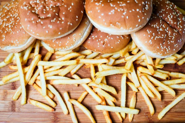 Burger buns with french fries on wooden background — Stock Photo, Image