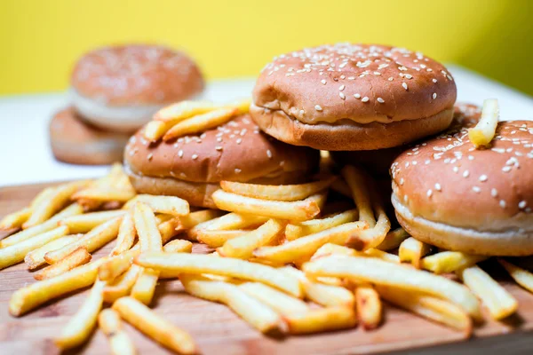 Bollos de hamburguesa con papas fritas sobre fondo de madera —  Fotos de Stock