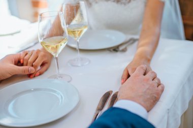 Gelin ve damat bir restoranda birbirimizin elini tutuyor