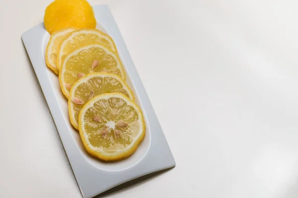 Кусочки лимона на белой тарелке. Isolated — стоковое фото