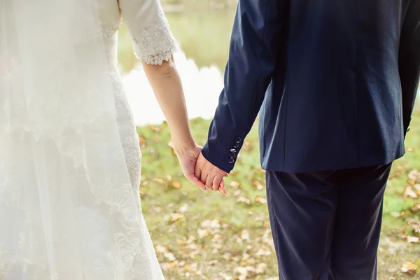 Las manos de la pareja recién casada con anillos de boda — Foto de Stock