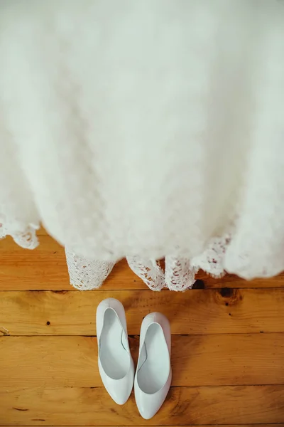 Vit bröllop skor och klänning på trä bakgrund — Stockfoto