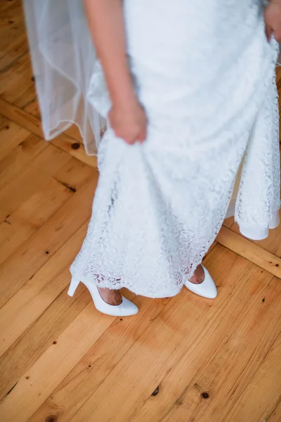 Chaussures de mariage blanches et robe sur le fond en bois — Photo