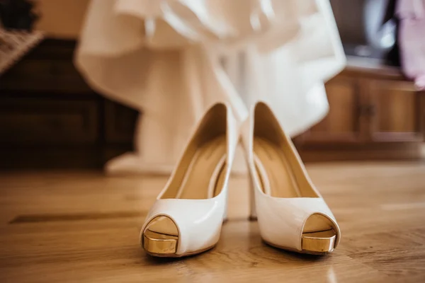 Wedding shoes and dress on the background — Stock Photo, Image