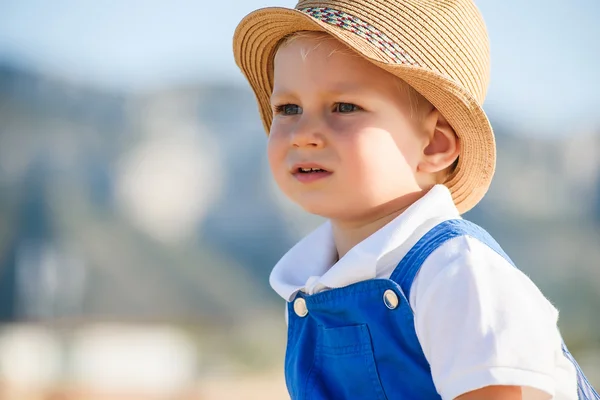 可爱的金发男孩在帽子和蓝色整体 — 图库照片