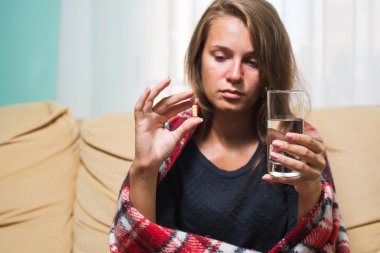 Hasta kadın hap ve su bardağı tutan