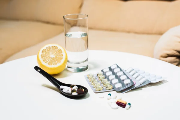 Pastillas de primer plano, limón y vaso de agua en la mesa — Foto de Stock