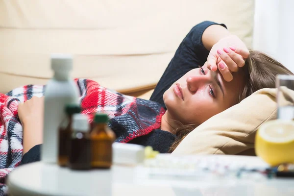 Donna malata sdraiata sul divano sotto la coperta di lana — Foto Stock