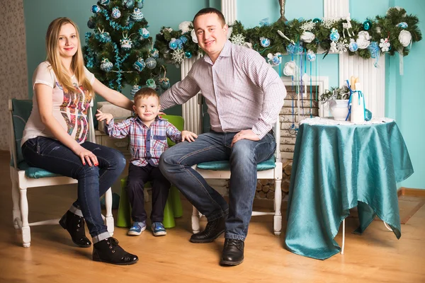Молода вагітна мати, батько та їхня дитина святкують Різдво вдома — стокове фото