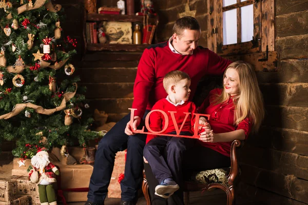 Junge schwangere Mutter, Vater und kleiner Sohn feiern Weihnachten zu Hause — Stockfoto