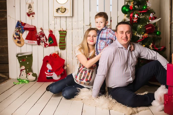 Jovem mãe grávida, pai e filho pequeno celebrando o Natal em casa — Fotografia de Stock