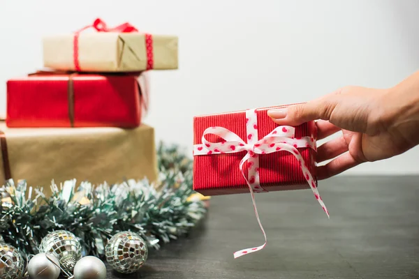 Regalos de Navidad en una mesa con fondo blanco y regalo de mano — Foto de Stock