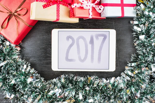 Närbild av julklappar på bordet med tablett och 2017 Inskription — Stockfoto