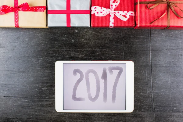 Närbild av julklappar på bordet med tablett och 2017 Inskription — Stockfoto