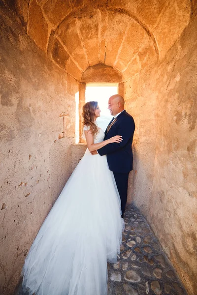 新婚旅行の城の窓の背景に抱擁 — ストック写真