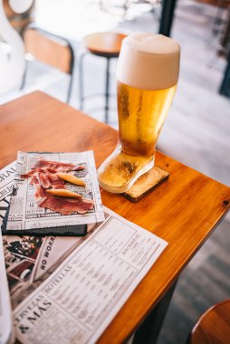 Lezzetli İspanyol jambonlu bira çizmeleri ahşap bir masada.
