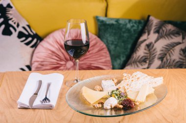 Masada şarap için üzüm ve çerez tabağı var.