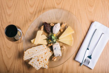 Bir tabak peynir. Cevizli, lezzetli peynir karışımı, tatlım. Tabakta tadımlık yemek. Üst görünüm