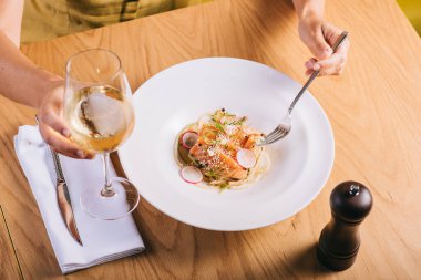 Som balıklı spagetti bir bardak beyaz şarapla yenir.