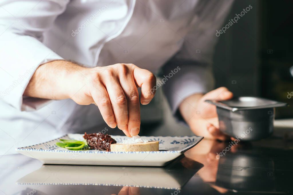 the chef decorates a plate of foie gras