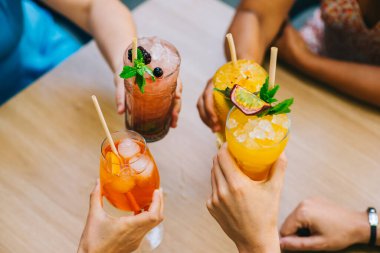 Öğleden sonra terasta kadeh tokuşturup kutlama yapan bir grup genç arkadaş.