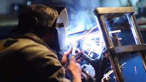 Automaster weld the frame of a custom motorcycle in the garage. — Stock Video