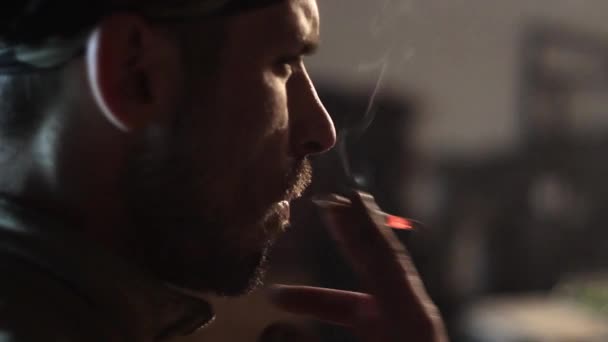 Muž kouří cigaretu, ladění do práce v garáži. — Stock video
