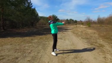 Olgun kadın ormanda açık havada çalıştırmadan önce ısınma.