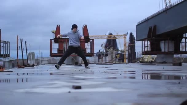 B-boy bailando break dance en la zona industrial. Puente inacabado en la zona industrial . — Vídeo de stock