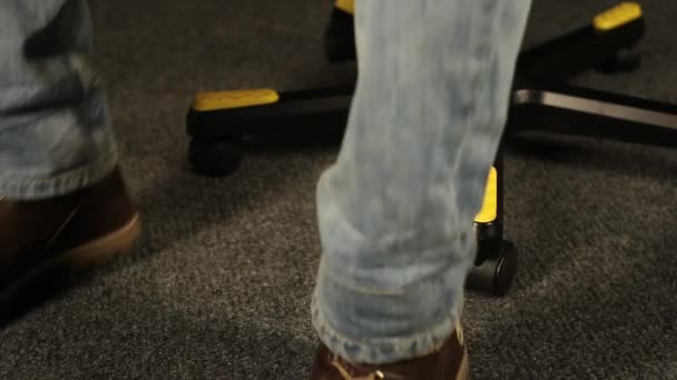 Pieds sur la surface caoutchoutée de la chaise de bureau transversale — Video