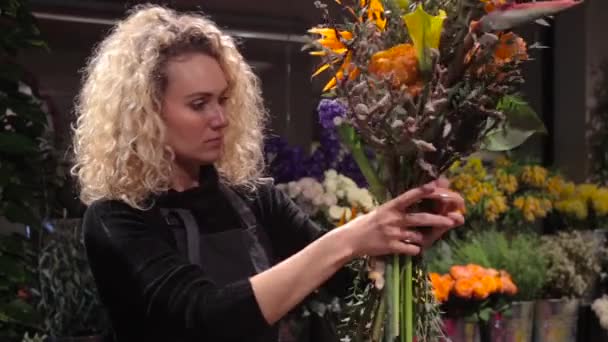 Gyönyörű nő virágárus, hogy egy csokor virág bolt — Stock videók
