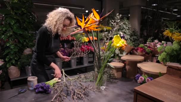 Linda florista mulher fazendo um buquê na loja de flores — Vídeo de Stock
