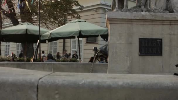 Lviv, Ukrayna - 7 Ekim 2015: yaz café Pazar Meydanı Belediye Binası yanındaki eski çeşme — Stok video