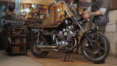 Motorcu parçaları motosiklet garajda toplar