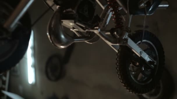 Байкер собирает в частях мотоцикл в гараже — стоковое видео