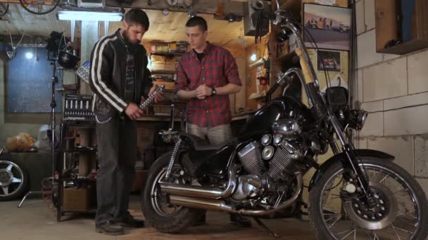 Mann spricht von Motorrad mit Automechaniker in Garage — Stockvideo