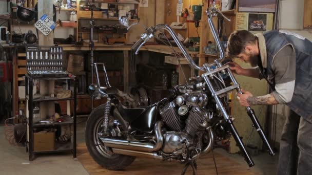 Biker collects in parts motorcycle in the garage — Stock Video