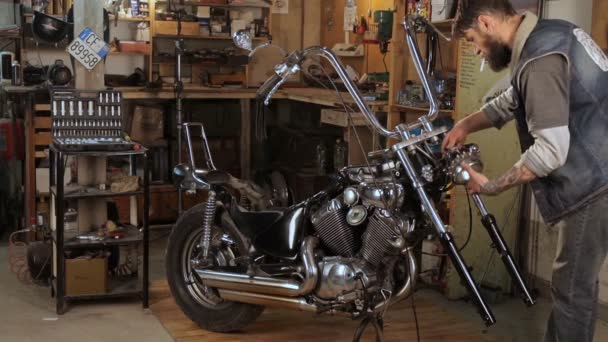 Biker collects in parts motorcycle in the garage — Stock Video