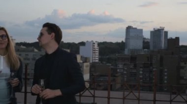 İnsanlar konuşmak ve çatıda bir ofis binası yaz akşamları içme