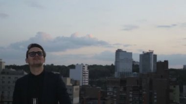 İnsanlar konuşmak ve çatıda bir ofis binası yaz akşamları içme