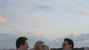 İnsanlar konuşmak ve çatıda bir ofis binası yaz akşamları içme