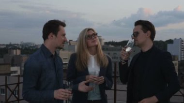 İnsanlar konuşmak ve çatıda bir ofis binası yaz akşamları içme