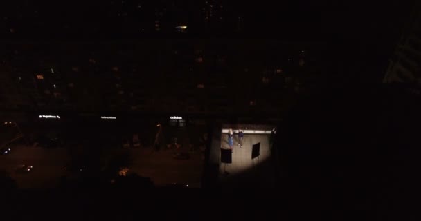 Młodzi faceci na dachu budynku w centrum miasta w nocy — Wideo stockowe