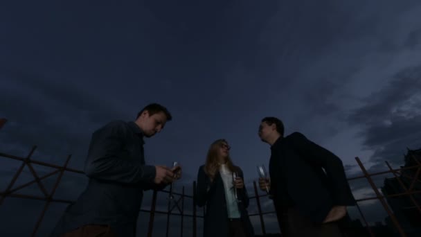 Menschen reden und trinken auf dem Dach eines Bürogebäudes an einem Sommerabend — Stockvideo