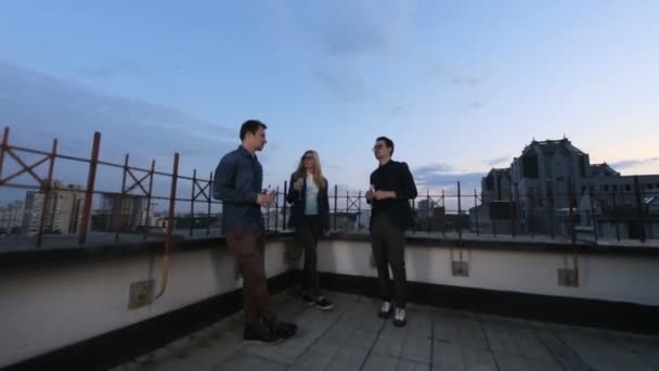 Люди розмовляють і п'ють на даху офісна будівля в літній вечір — стокове відео
