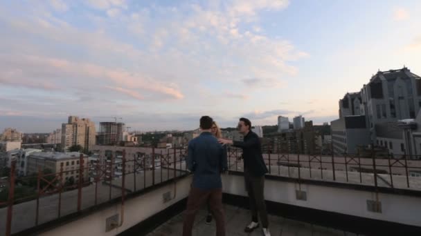 Pessoas conversando e bebendo no telhado um prédio de escritórios na noite de verão — Vídeo de Stock