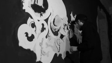 Sanatçı resim beyaz grafiti kafatası siyah duvar ile
